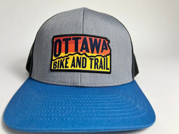 Ottawa Bike and Trail, LLC Shop Merch OBAT Logo Sunrise Trucker Hat